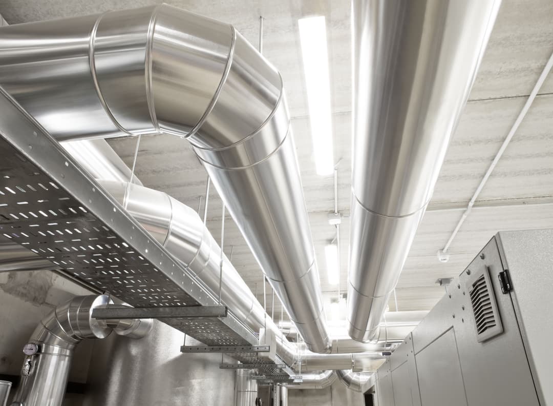 Professional cleanroom mechanical plant installation showing complex insulated HVAC ductwork and HEPA filtration infrastructure mounted above a classified cleanroom ceiling.