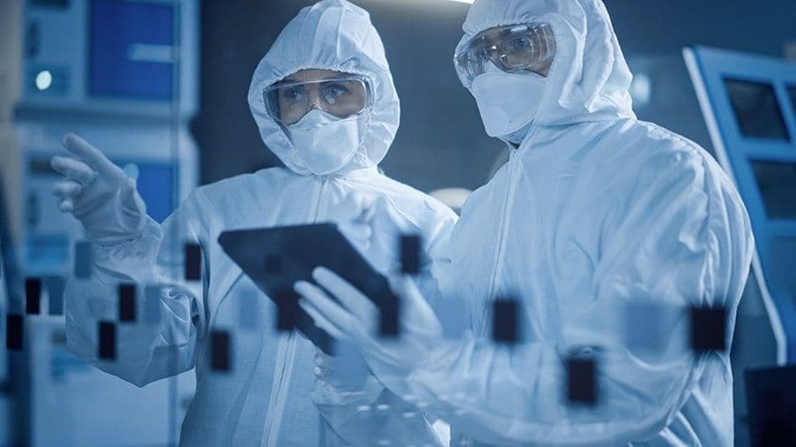 Two cleanroom workers fully gowned up in a cleanroom
